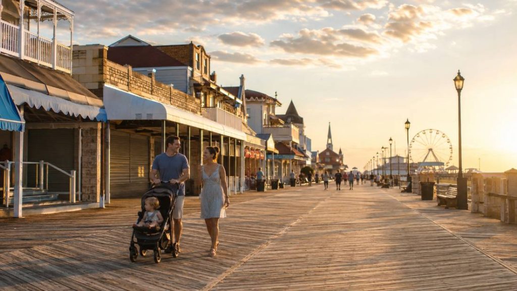 Family with stroller walking the Ocean City NJ boardwalk in morning light